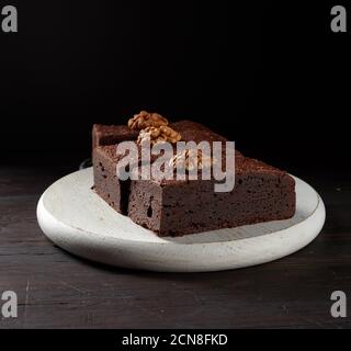 Stapel von gebackenen Stücken Brownie Schokoladenkuchen mit Nüssen Auf einem Holzbrett Stockfoto