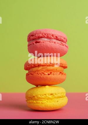 Drei runde mehrfarbige gebackene Makronen, Dessert liegt übereinander Stockfoto