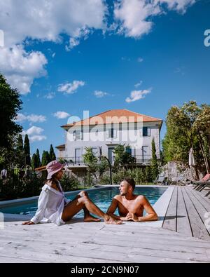 Französisches Ferienhaus mit Holzterrasse und Swimmingpool in der Ardeche Frankreich. Paar entspannen am Pool mit Holzterrasse duri Stockfoto