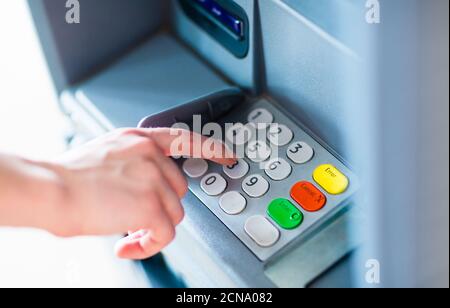 Nahaufnahme der Hand Eingabe PIN-Passwort auf ATM Bank-Tastatur, um Bargeld abzuheben. Stockfoto