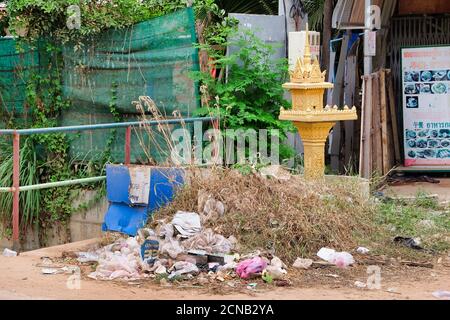 Kambodscha, Siem Reap 12/08/2018 ein kleines buddhistisches Heiligtum inmitten der Müllberge auf einer Stadtstraße, eine Müllhalde in der Nähe eines religiösen Objekts Stockfoto