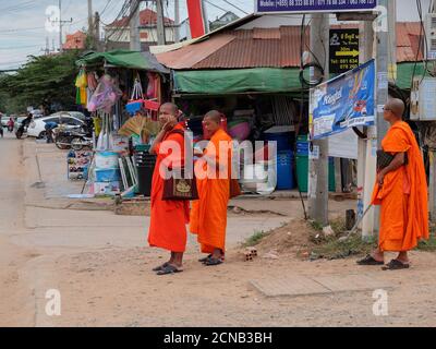 Kambodscha, Siem Reap 12/08/2018 mehrere buddhistische Mönche in orangefarbenen Gewändern stehen auf einer Stadtstraße Stockfoto