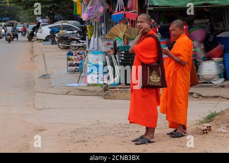 Kambodscha, Siem Reap 12/08/2018 mehrere buddhistische Mönche in orangefarbenen Gewändern stehen auf einer Stadtstraße Stockfoto