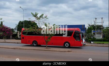 Kambodscha, Siem Reap 12/08/2018 roter Bus fährt entlang einer Stadtstraße, wolkig am Abend Stockfoto