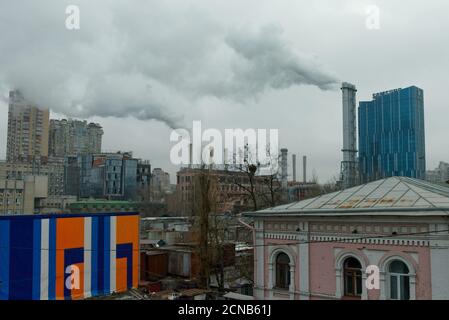 Kiew, Ukraine, 25. Februar 2020. Rauch kommt von Kaminen über der Stadt an einem bewölkten Tag. Hässliche Stadtlandschaft. Stockfoto