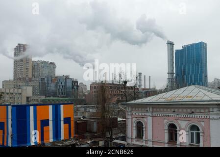 Kiew, Ukraine, 25. Februar 2020. Rauch kommt von Kaminen über der Stadt an einem bewölkten Tag. Hässliche Stadtlandschaft. Stockfoto