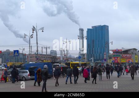 Kiew, Ukraine, 25. Februar 2020. Fußgänger in der Nähe des Hauptbahnhofs. Hauptquartier Wohnung DTEK. Rauch kommt aus den Schornsteinen. Stockfoto