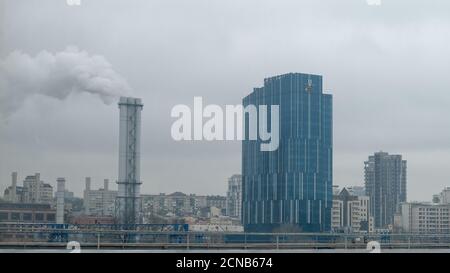 Kiew, Ukraine, 25. Februar 2020. DTEK modernes Büro an einem bewölkten Tag. Die Rohre werfen Rauch in den Himmel. Sitz der DTEK, Energieholding. Stockfoto