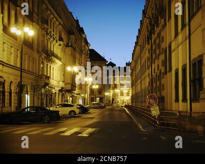 Prag, Tschechische Republik, 13. Oktober 2019. Moderne Autos an einer alten europäischen Straße geparkt. Dämmerung und Licht der Laternen. Stockfoto