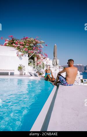 Santorini Griechenland, junges Paar auf Luxus-Urlaub auf der Insel Santorini beobachten Sonnenaufgang durch die blaue Kuppel Kirche und weiß Stockfoto