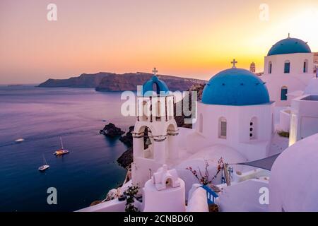 Sonnenuntergang auf der Insel Santorini Griechenland, wunderschönes weiß getünchtes Dorf Oia mit Kirche und Windmühle während des Sonnenuntergangs Stockfoto