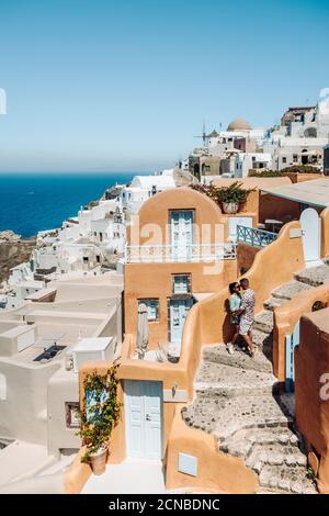 Santorini Griechenland, junges Paar auf Luxus-Urlaub auf der Insel Santorini beobachten Sonnenaufgang durch die blaue Kuppel Kirche und weiß Stockfoto