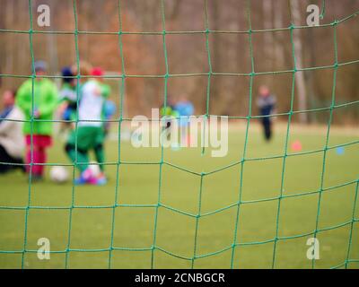 Fußballtraining. Gekreuzte Fußballnetze Fußball im Tornetz mit Gras Stockfoto