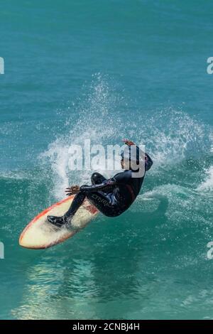 Spektakuläre Action, während ein Surfer eine Welle in Fistral in Newquay in Cornwall reitet. Stockfoto