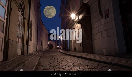 Prager Nachtstraße mit Mond am Himmel. Elemente dieses Bildes, die von der NASA eingerichtet wurden. Stockfoto