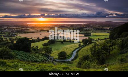 Sommeruntergang über dem Severn Vale vom Coaley Peak, Gloucestershire aus gesehen. Stockfoto