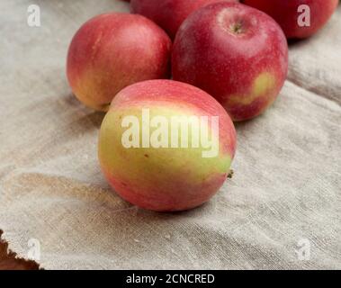 Rote reife Äpfel liegen auf einer grauen Leinenserviette Stockfoto