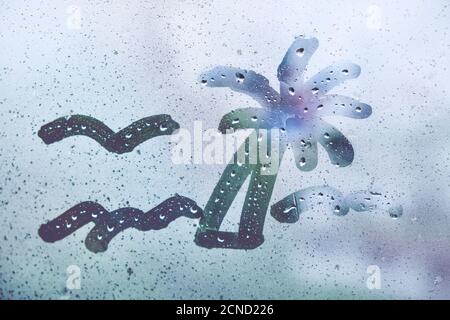 Abstrakte Zeichnung von Palmen und Meer auf Nebelfenster. Stockfoto