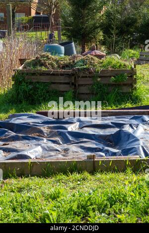 Kompostbehälter und ein Hochbeet mit Kunststoffabdeckung, das in einer Kleingartenanlage steht Stockfoto