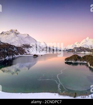 Rosafarbener Sonnenaufgang auf dem gefrorenen Sils-See und dem schneebedeckten Piz Da La Margna, Engadin, Kanton Graubünden, Schweiz, Europa Stockfoto