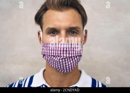 Junger Mann trägt Gesichtsschutzmaske, um Corona-Virus zu vermeiden Verbreitung - Gesundheitskonzept Stockfoto