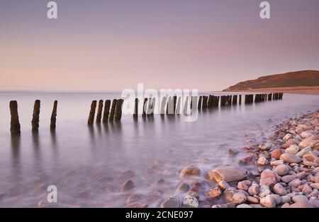 Blick in die Dämmerung auf die verfaulende Verteidigung am Kiesstrand von Porlock Weir, in der Nähe von Porlock, im Exmoor National Park, Somerset, England, Vereinigtes Königreich Stockfoto