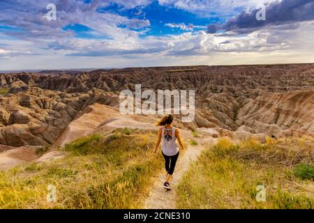 Frau, die ihren Weg durch die malerischen Badlands, South Dakota, USA, wandert Stockfoto