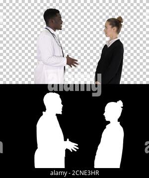 Männlicher afrikanischer Arzt im Gespräch mit weiblicher Patientin, Alpha-Kanal Stockfoto