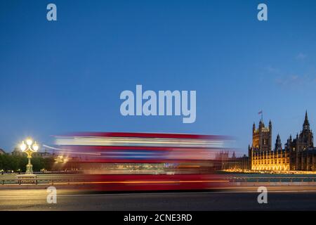 Ein roter Londoner Bus fährt in einer Unschärfe vorbei über Westminster Bridge, London, England, Großbritannien, Europa Stockfoto