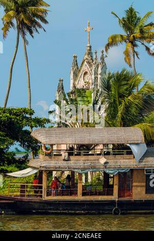 Alte Kirche mit patinierten Fassade und festgemacht Hausboot auf einem Backwaters Kreuzfahrt Besucherstop, Alappuzha (Alleppey), Kerala, Indien, Asien Stockfoto