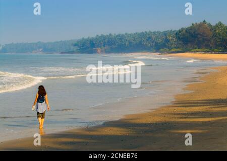 Alleinreisende auf schönen palmengesäumten, Kizhunna Strand, südlich von Kannur an Keralas Nordküste, Kizhunna, Kannur, Kerala, Indien, Asien Stockfoto