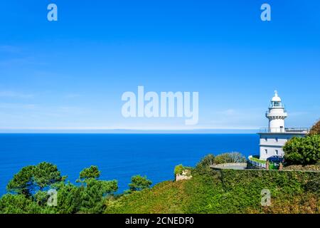 Weißer Leuchtturm am Ufer gegen das blaue Meer. Donostia San Sebastian, Baskenland, Spanien. Speicherplatz kopieren. Stockfoto