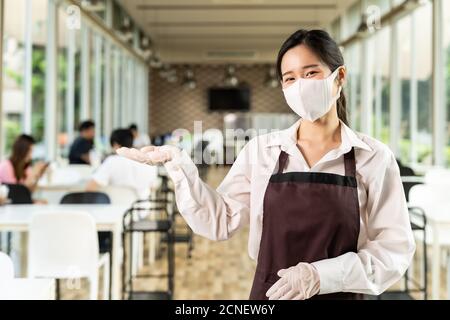Porträt der Kellnerin mit Gesichtsbemalung im neuen normalen Restaurant Hintergrund Stockfoto