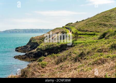 Eine Gruppe von Wanderern verlässt Belvoir Bay, Richtung Süden auf dem Küstenpfad rund um Herm Island, Guernsey, Channel Islands, Großbritannien. Stockfoto