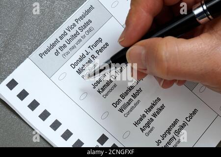 Nahaufnahme einer Hand mit Stift, der einen Absentee ausfüllt Wahl für North Carolina Stockfoto