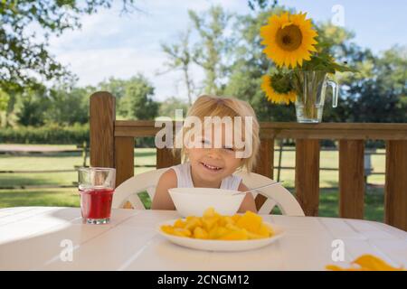 Kind, Kleinkind Junge, mit Frühstück am Morgen, sitzen auf der Veranda von Camping van, Reisen Sommerzeit, Familienurlaub Stockfoto