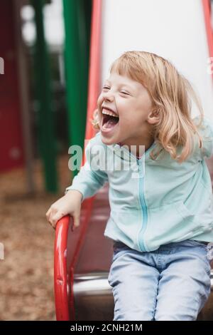 Kleine behinderte Mädchen spielt auf dem Spielplatz Stockfoto