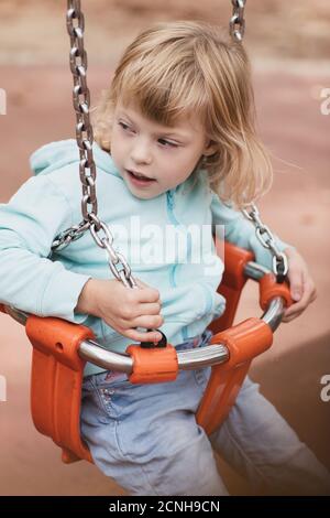 Kleine behinderte Mädchen spielt auf dem Spielplatz Stockfoto