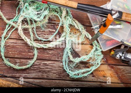 Verschiedene Angeltacles mit Rute und Rollen auf hölzernem braunem Hintergrund. Mockap für Werbung und Veröffentlichung. Stockfoto