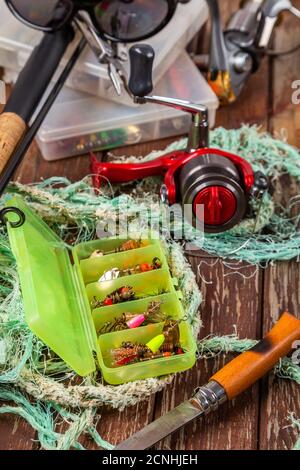 Verschiedene Angeltacles mit Rute und Rollen auf hölzernem braunem Hintergrund. Mockap für Werbung und Veröffentlichung. Stockfoto