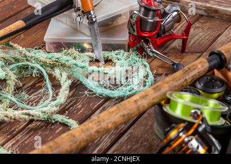 Verschiedene Angeltacles mit Rute und Rollen auf hölzernem braunem Hintergrund. Mockap für Werbung und Veröffentlichung. Stockfoto