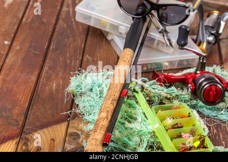 Verschiedene Angeltacles mit Rute und Rollen auf hölzernem braunem Hintergrund. Mockap für Werbung und Veröffentlichung. Stockfoto