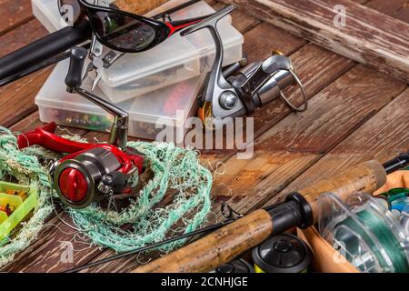 Verschiedene Angeltacles mit Rute und Rollen auf hölzernem braunem Hintergrund. Mockap für Werbung und Veröffentlichung. Stockfoto