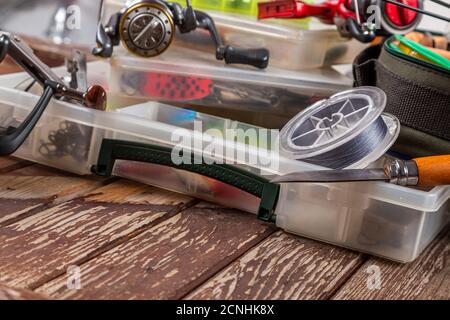 Verschiedene Angeltacles mit Rute und Rollen auf hölzernem braunem Hintergrund. Mockap für Werbung und Veröffentlichung. Stockfoto