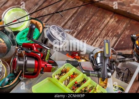 Verschiedene Angeltacles mit Rute und Rollen auf hölzernem braunem Hintergrund. Mockap für Werbung und Veröffentlichung. Stockfoto