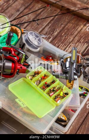 Verschiedene Angeltacles mit Rute und Rollen auf hölzernem braunem Hintergrund. Mockap für Werbung und Veröffentlichung. Stockfoto