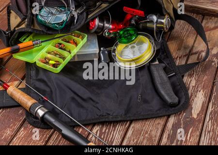 Verschiedene Angeltacles mit Rute und Rollen auf hölzernem braunem Hintergrund. Mockap für Werbung und Veröffentlichung. Stockfoto