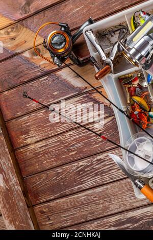 Verschiedene Angeltacles mit Rute und Rollen auf hölzernem braunem Hintergrund. Mockap für Werbung und Veröffentlichung. Stockfoto