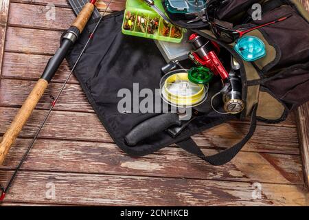 Verschiedene Angeltacles mit Rute und Rollen auf hölzernem braunem Hintergrund. Mockap für Werbung und Veröffentlichung. Stockfoto