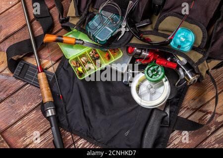 Verschiedene Angeltacles mit Rute und Rollen auf hölzernem braunem Hintergrund. Mockap für Werbung und Veröffentlichung. Stockfoto